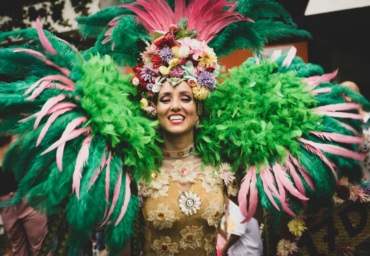 Person wearing a Vibrant Carnival Costume with colorful feathers and floral headpiece perfect for a festive celebrations.