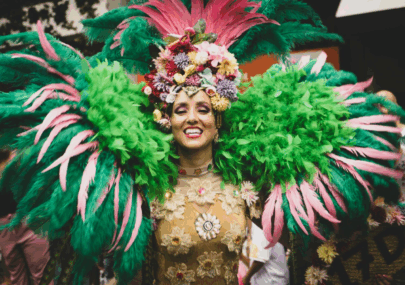 Person wearing a Vibrant Carnival Costume with colorful feathers and floral headpiece perfect for a festive celebrations.